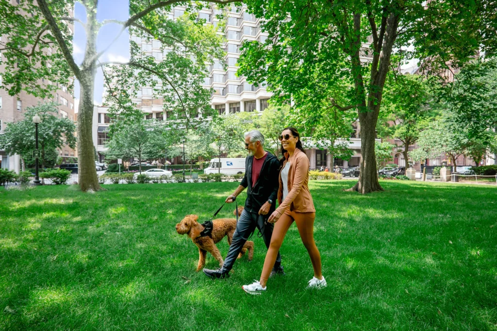 Couple walking with their dog in Rittenhouse Square Park.