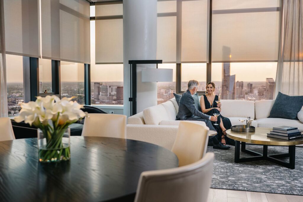 Modern living space at The Laurel with sunset city views with a couple sitting on the couch